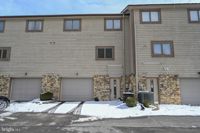 view of front facade featuring cooling unit and stone siding