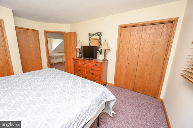 bedroom featuring baseboards, multiple closets, and light colored carpet