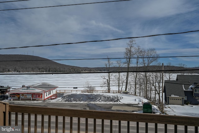 snow covered deck with a garage and a mountain view