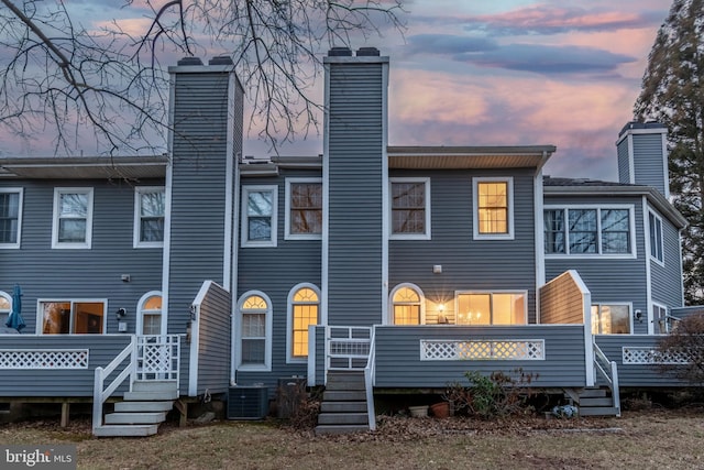 back of house featuring a deck, central AC unit, and a chimney