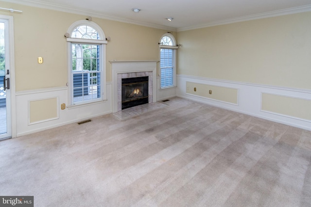 unfurnished living room with visible vents, a fireplace, ornamental molding, wainscoting, and carpet flooring