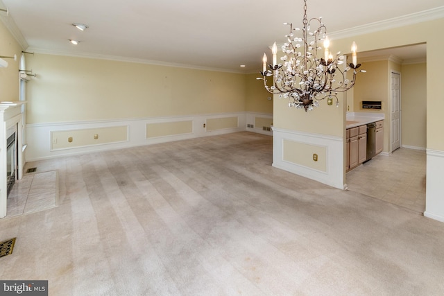 interior space with a tiled fireplace, ornamental molding, light carpet, wainscoting, and a decorative wall