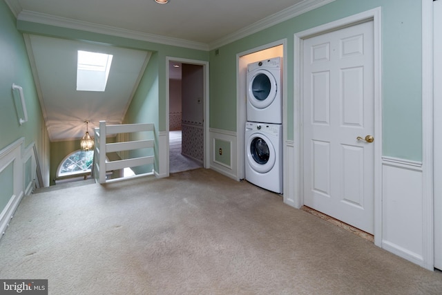 washroom with stacked washer / drying machine, carpet, a skylight, and laundry area