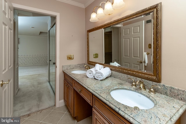 bathroom featuring tile patterned floors, double vanity, crown molding, and a sink