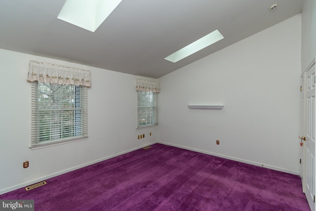 unfurnished room with lofted ceiling with skylight, carpet flooring, baseboards, and visible vents