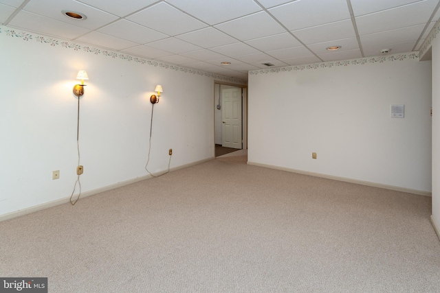 basement with carpet, baseboards, and a paneled ceiling