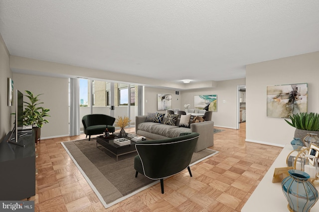 living room with a textured ceiling and baseboards