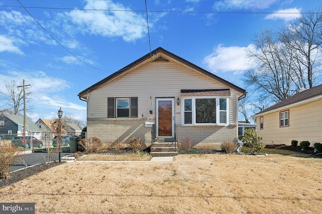 bungalow-style home featuring fence and brick siding