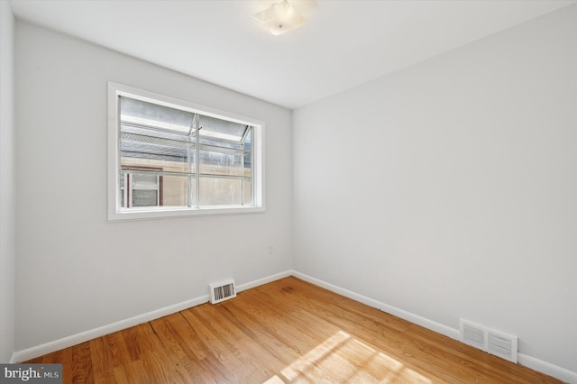 spare room with baseboards, visible vents, and light wood-style flooring