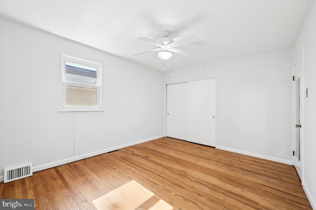 unfurnished bedroom with a ceiling fan, a closet, visible vents, and wood finished floors