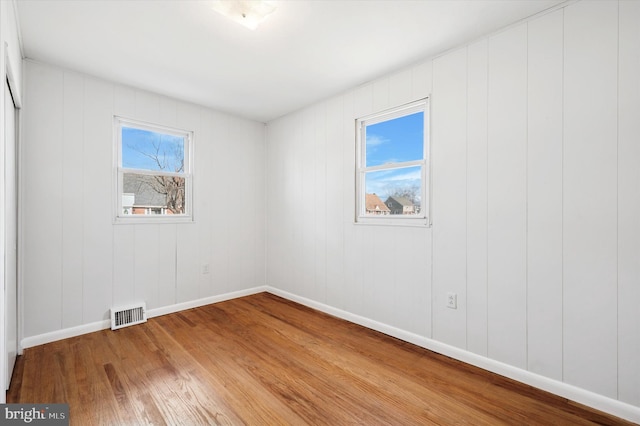 unfurnished bedroom featuring baseboards, visible vents, and wood finished floors