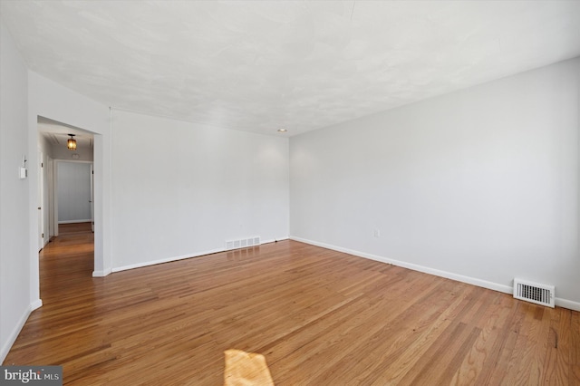 unfurnished room with visible vents and wood finished floors