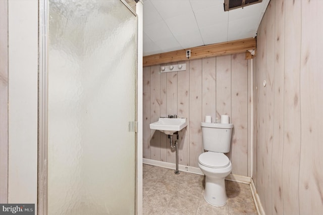 bathroom featuring baseboards, visible vents, wooden walls, and toilet