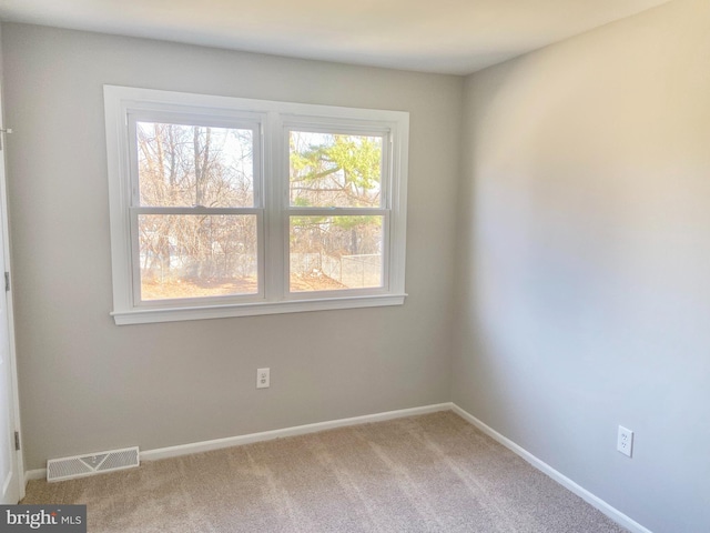 carpeted empty room with visible vents and baseboards