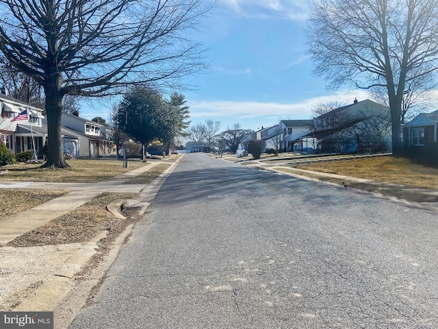 view of street with a residential view, curbs, and sidewalks