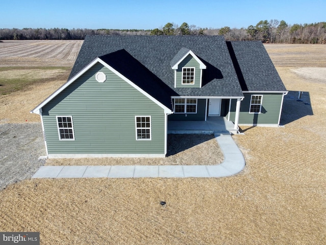 view of front of home featuring a patio area and roof with shingles