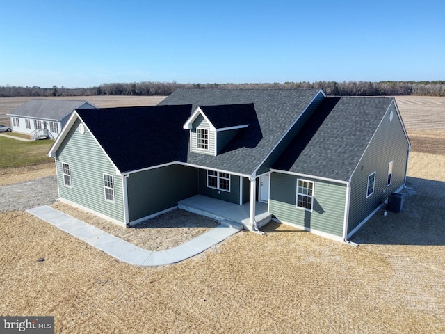 view of front of home featuring a shingled roof and a patio area