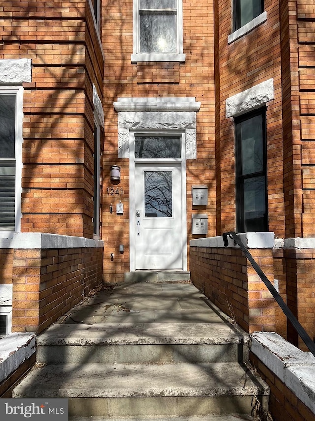 view of exterior entry with brick siding