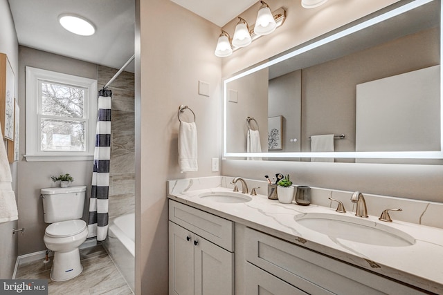 full bathroom featuring double vanity, shower / bath combo with shower curtain, a sink, and toilet