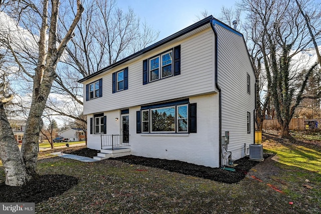 colonial home with brick siding and central AC