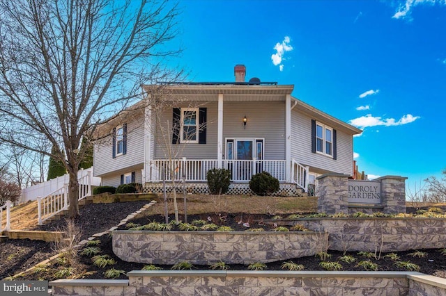 view of front of home with a porch and fence