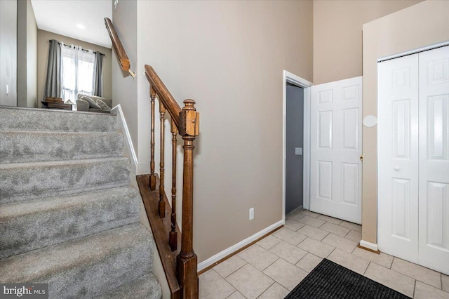 staircase with baseboards and tile patterned floors