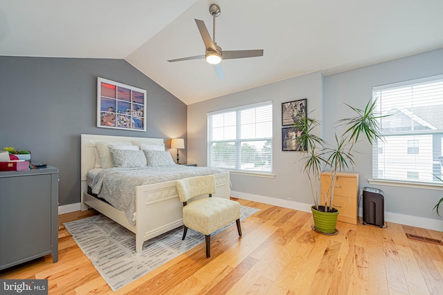 bedroom with multiple windows and light wood-style flooring