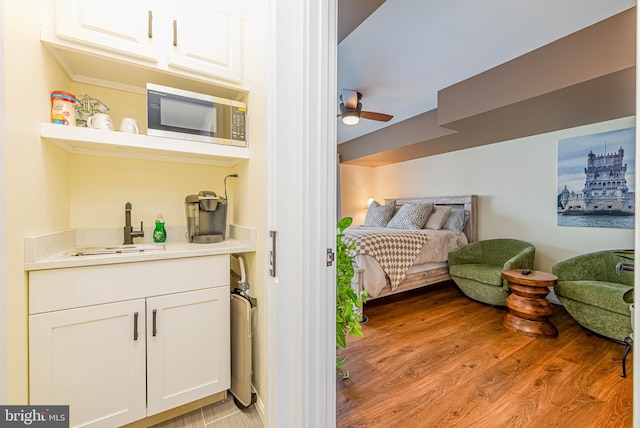 bedroom featuring ceiling fan, a sink, and light wood-style floors