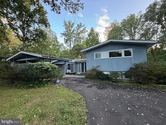 view of front facade featuring a front lawn and aphalt driveway