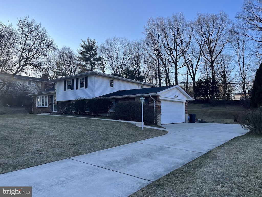 view of property exterior with an attached garage, brick siding, concrete driveway, and a yard