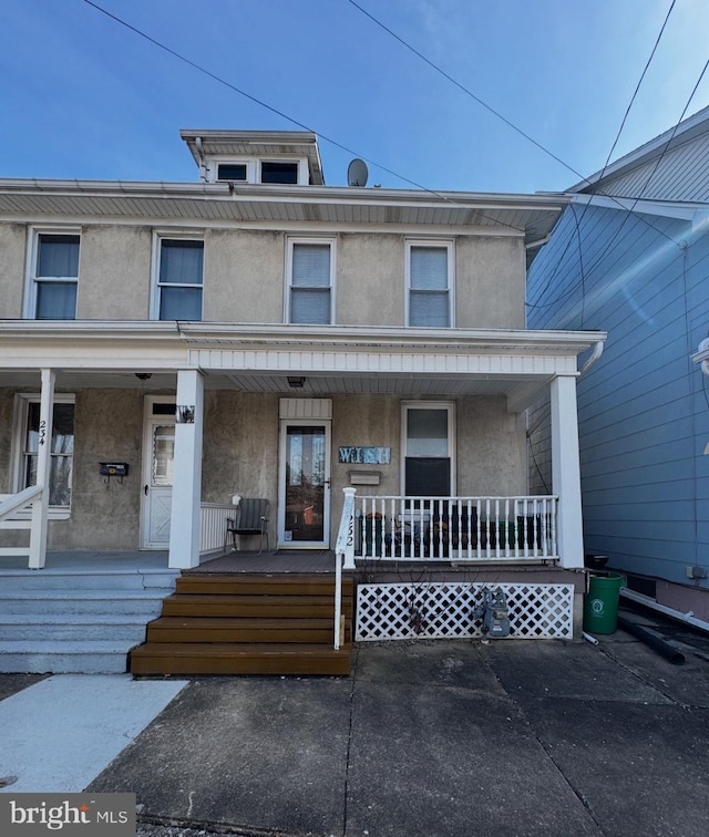 view of front of property featuring covered porch and stucco siding