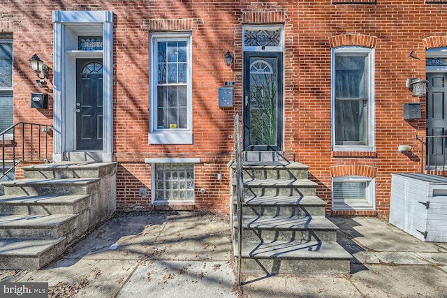 entrance to property with brick siding and a patio