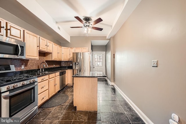 kitchen with tasteful backsplash, baseboards, a center island, stainless steel appliances, and a sink