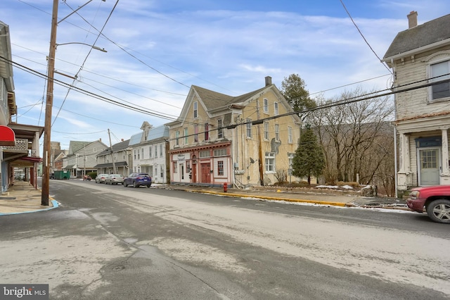 view of road with sidewalks, street lighting, a residential view, and curbs