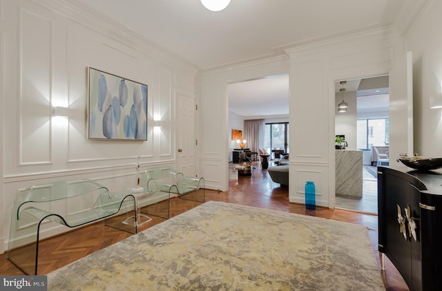 interior space featuring ornamental molding, decorative columns, and a decorative wall