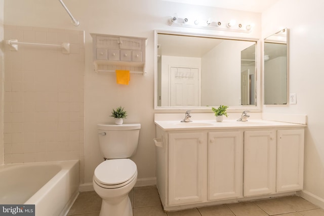 full bathroom featuring double vanity, a sink, toilet, and tile patterned floors