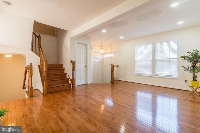 living room with wood-type flooring, visible vents, and recessed lighting