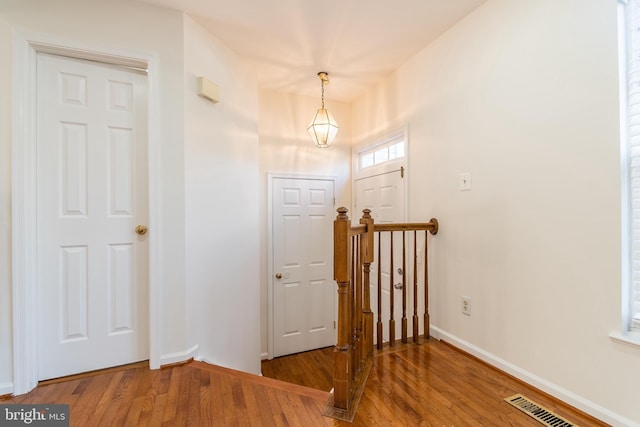 entryway featuring visible vents, baseboards, and wood finished floors