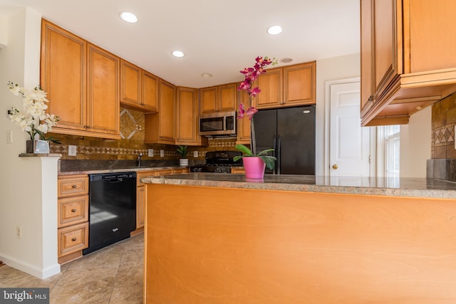 kitchen with light tile patterned floors, a peninsula, brown cabinets, black appliances, and tasteful backsplash