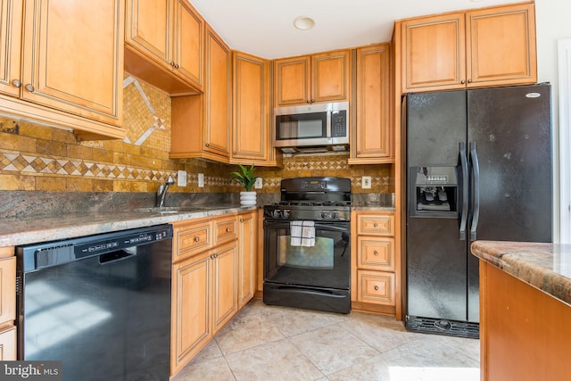 kitchen with brown cabinets, decorative backsplash, light tile patterned flooring, a sink, and black appliances