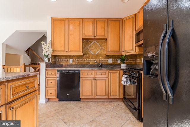 kitchen featuring light tile patterned floors, a sink, brown cabinets, black appliances, and tasteful backsplash