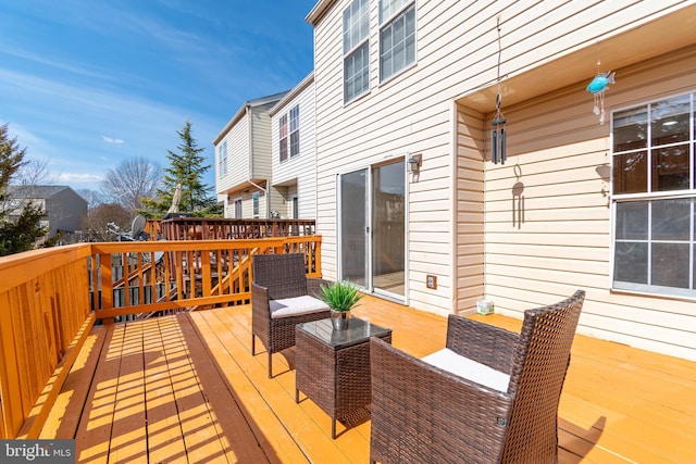 wooden terrace with an outdoor living space