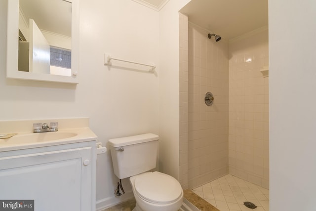 full bathroom with ornamental molding, tiled shower, vanity, and toilet