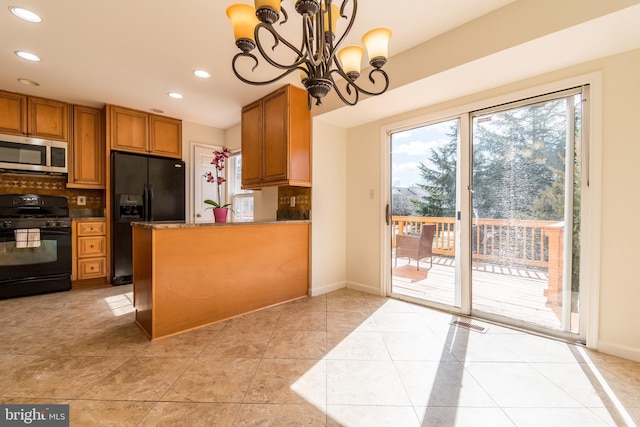 kitchen featuring light tile patterned floors, decorative backsplash, brown cabinets, black appliances, and a notable chandelier