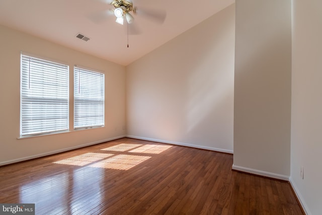 spare room featuring a ceiling fan, visible vents, baseboards, and hardwood / wood-style flooring