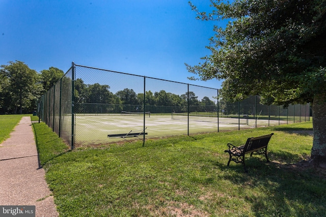 view of sport court with a yard and fence