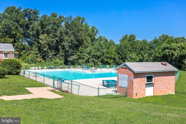 pool featuring a patio, a yard, and fence