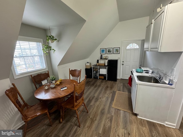 dining space featuring lofted ceiling and dark wood finished floors