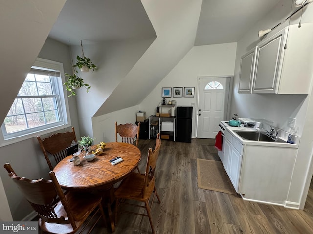 dining area featuring dark wood-type flooring and vaulted ceiling