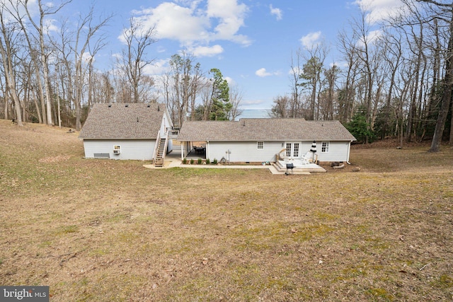 rear view of property featuring crawl space, a yard, roof with shingles, and a patio area